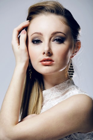 Blonde girl on white background close-up.